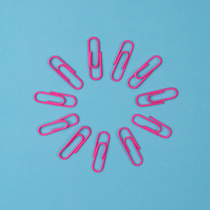 Pink paperclips laid out in a circle to represent linking